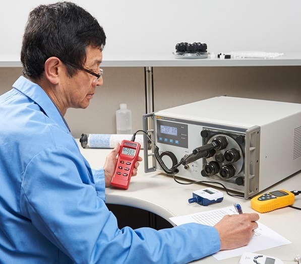 Calibration Technician Calibrating Humidity Sensors with a Humidity Generator Calibrator